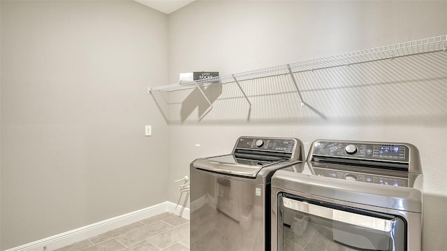 laundry room with light tile patterned floors and washer and clothes dryer