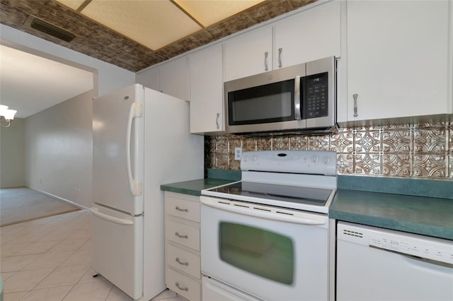 kitchen featuring tasteful backsplash, white appliances, light tile patterned flooring, and white cabinets