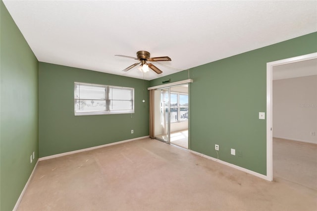 spare room with light colored carpet and ceiling fan