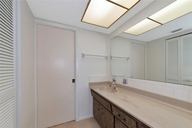 bathroom with vanity and decorative backsplash