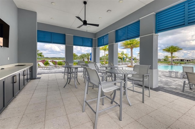 view of patio with ceiling fan and a community pool