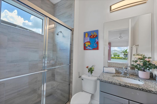 bathroom featuring a shower with shower door, toilet, and vanity