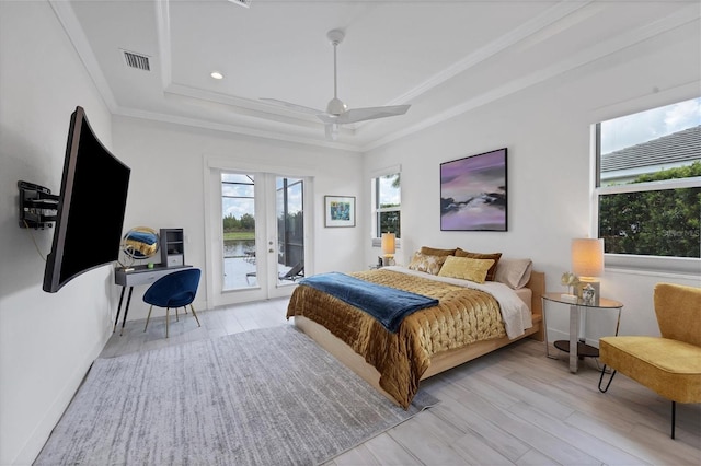 bedroom featuring french doors, light hardwood / wood-style flooring, a tray ceiling, access to outside, and ceiling fan