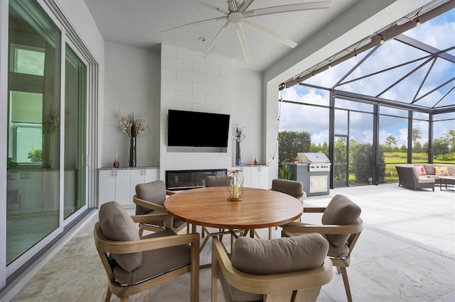 sunroom / solarium with a fireplace and ceiling fan