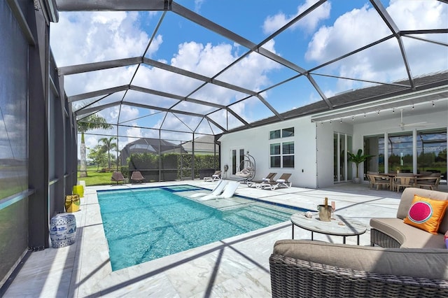 view of swimming pool featuring a lanai and a patio