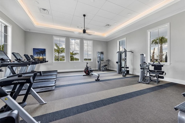 gym with a tray ceiling, ornamental molding, and carpet