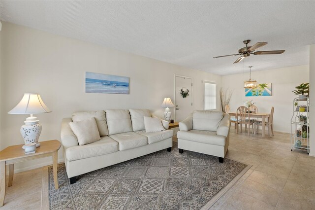 tiled living room with a textured ceiling and ceiling fan