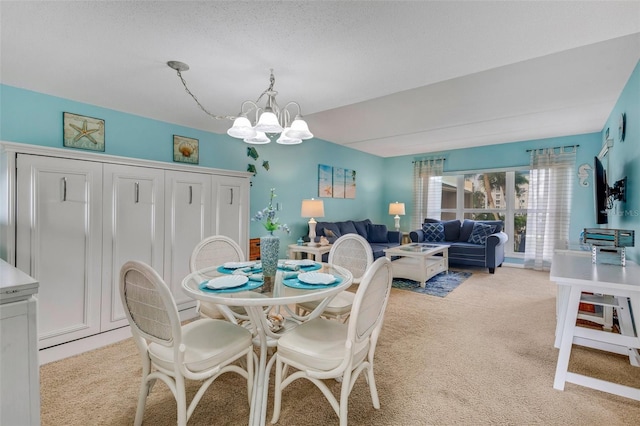 dining space featuring light carpet and an inviting chandelier