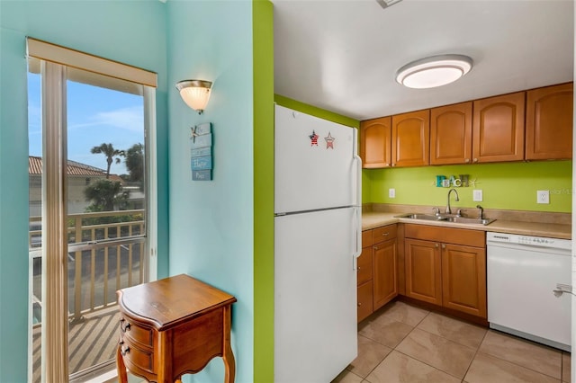 kitchen with sink, white appliances, and light tile patterned floors