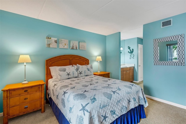 bedroom with ensuite bath, light colored carpet, and a closet