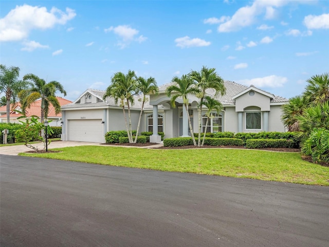 view of front of property featuring a garage and a front lawn