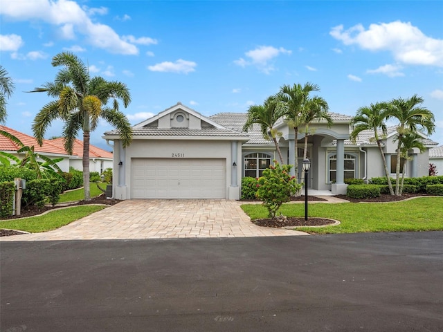 view of front of home featuring a garage, a front lawn, and central AC unit