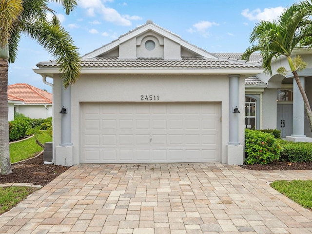 view of front of property featuring a garage and central AC unit