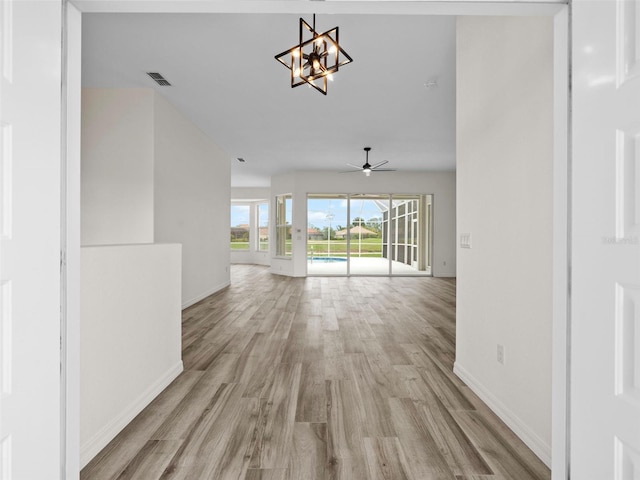 empty room featuring light hardwood / wood-style flooring and ceiling fan with notable chandelier