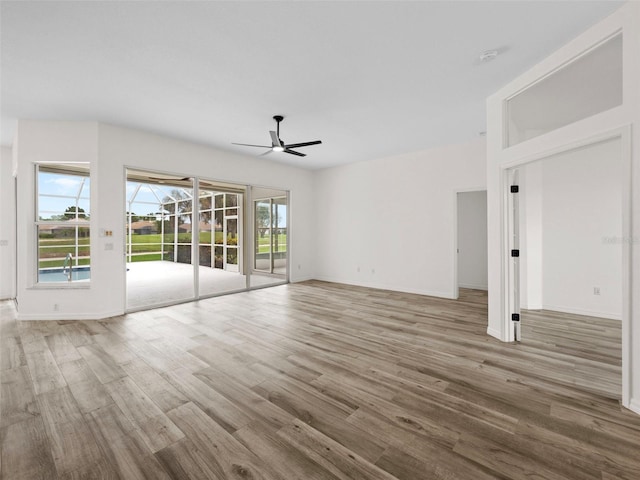 unfurnished living room featuring hardwood / wood-style flooring, ceiling fan, and a wealth of natural light