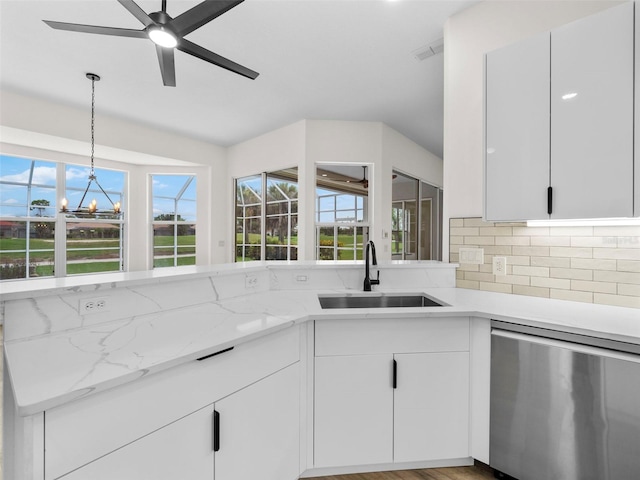 kitchen with light hardwood / wood-style flooring, sink, hanging light fixtures, stainless steel dishwasher, and light stone countertops