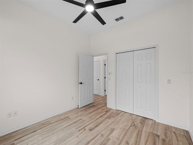 unfurnished bedroom with light hardwood / wood-style flooring, a closet, and ceiling fan