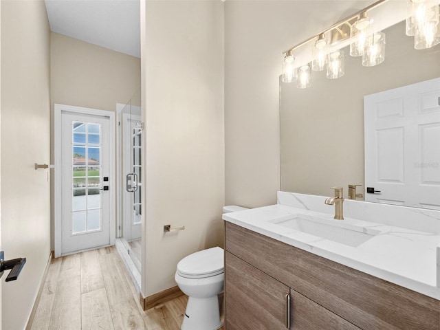 bathroom featuring hardwood / wood-style flooring, vanity, walk in shower, and toilet