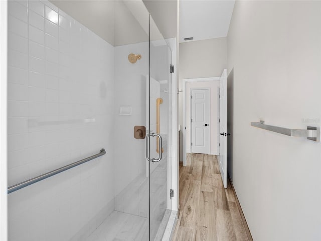 bathroom featuring a shower with door and hardwood / wood-style floors