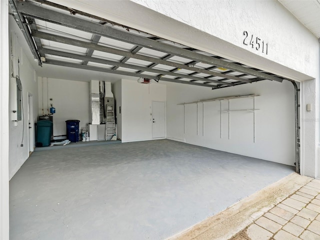 garage featuring a garage door opener and heating unit