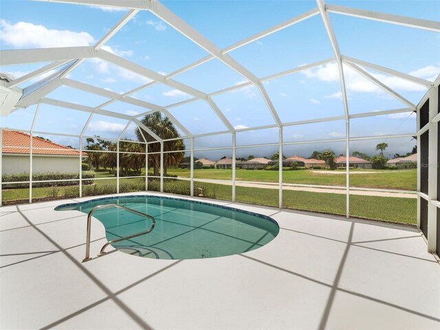 view of pool featuring a yard, a patio area, and a lanai