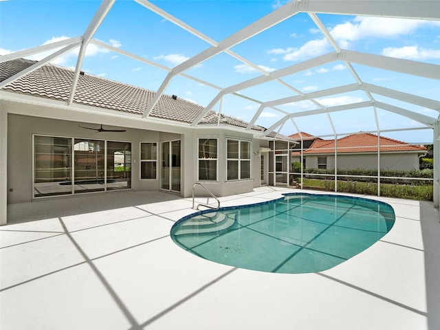 view of swimming pool with a patio area, ceiling fan, and glass enclosure