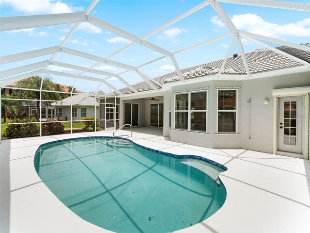 view of pool with a lanai, a patio area, and ceiling fan