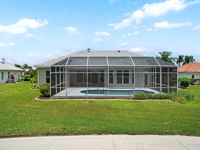 rear view of property featuring a lanai and a lawn