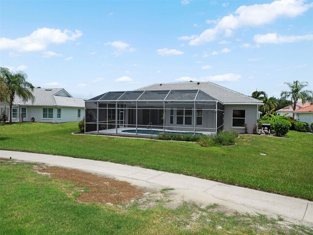 back of house featuring a pool, a lawn, and glass enclosure