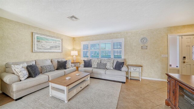 tiled living room featuring a textured ceiling