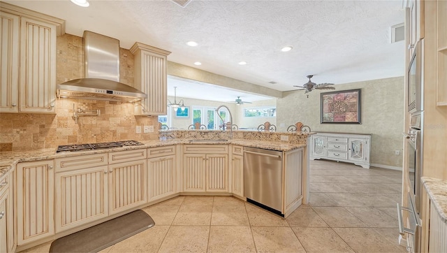 kitchen with stainless steel appliances, tasteful backsplash, a textured ceiling, kitchen peninsula, and wall chimney exhaust hood