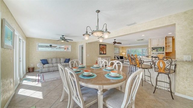 dining area with ceiling fan, sink, and light tile patterned floors