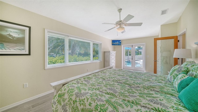 bedroom featuring light wood-type flooring, access to exterior, ceiling fan, and french doors