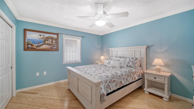 bedroom with ceiling fan, ornamental molding, a closet, and light hardwood / wood-style flooring