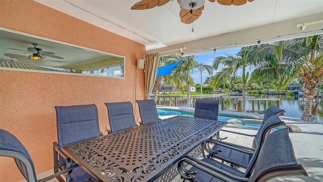 view of patio featuring a water view and ceiling fan