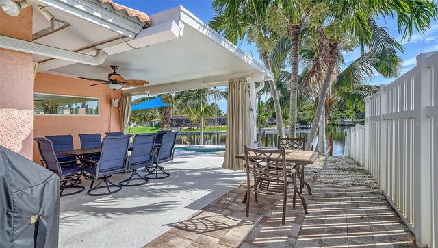 view of patio with ceiling fan and a water view