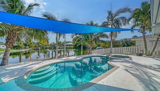 view of pool featuring a patio area, an in ground hot tub, and a water view