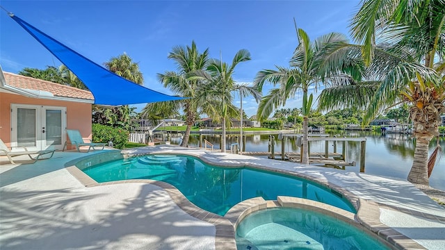 view of swimming pool with a water view, a patio, and an in ground hot tub