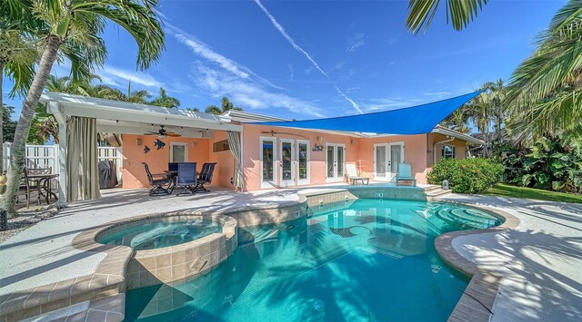 view of swimming pool featuring ceiling fan, a patio, an in ground hot tub, and french doors