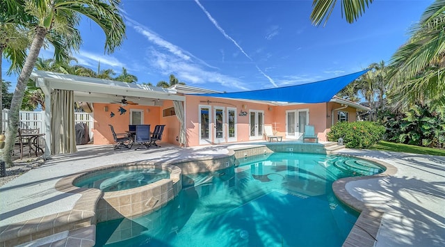 exterior space with a swimming pool with hot tub, a patio area, ceiling fan, and french doors