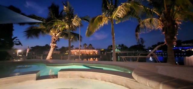 pool at night with a patio area