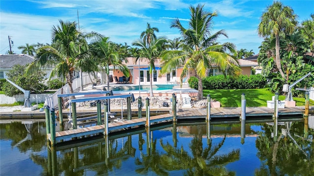 view of dock with a water view, a yard, a fenced in pool, and a patio