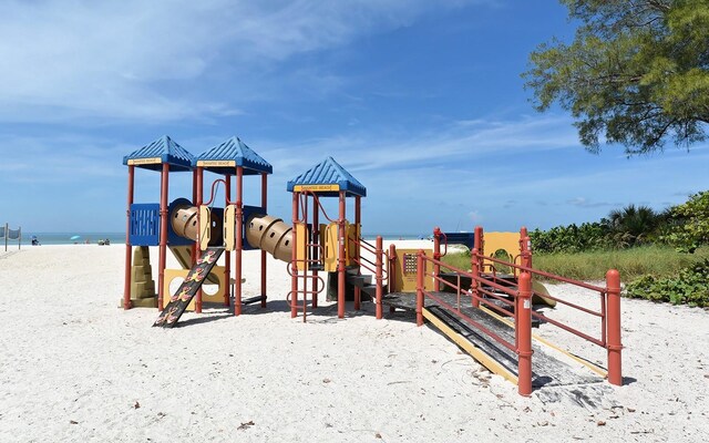 view of jungle gym with a view of the beach and a water view