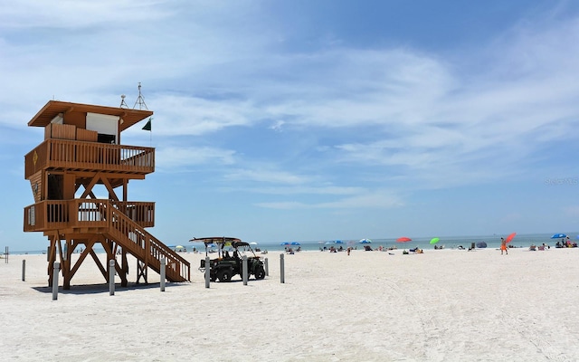 view of property's community with a water view and a beach view