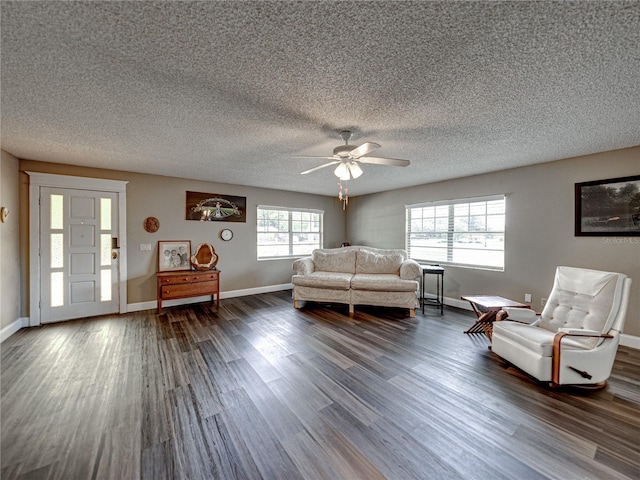 living area featuring a ceiling fan, dark wood finished floors, a textured ceiling, and baseboards