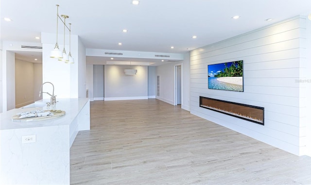 interior space with sink, a fireplace, and light wood-type flooring