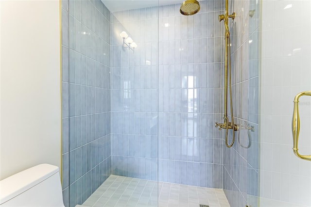 bathroom featuring tiled shower and toilet