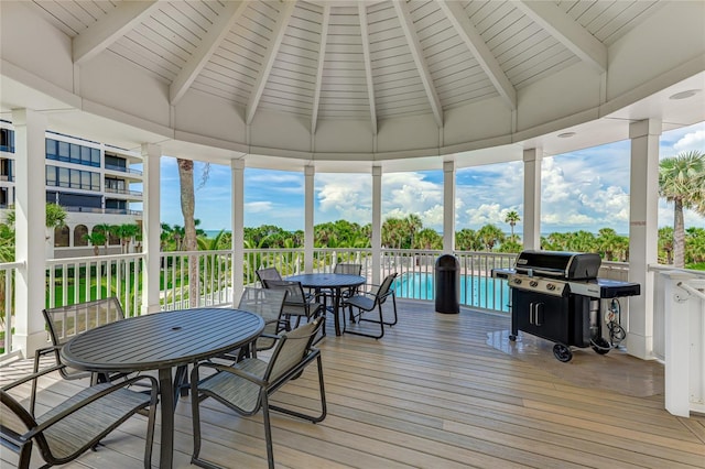 sunroom featuring lofted ceiling with beams