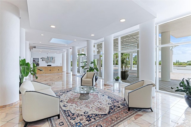 tiled living room featuring floor to ceiling windows, ornate columns, and a wealth of natural light