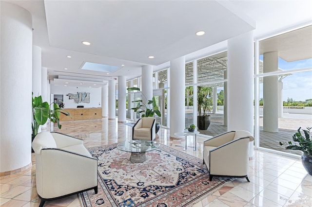 living room featuring decorative columns and floor to ceiling windows